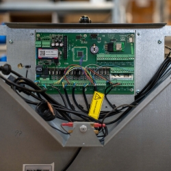 Nærbillede af elektronisk printplade i pillefyr under service.