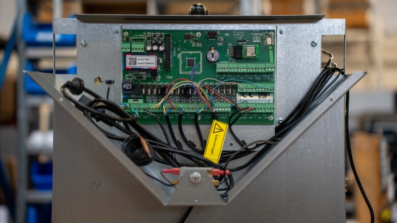 Nærbillede af elektronisk printplade i pillefyr under service.