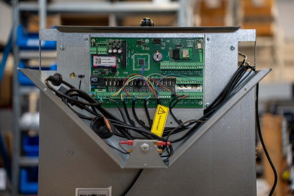 Nærbillede af elektronisk printplade i pillefyr under service.